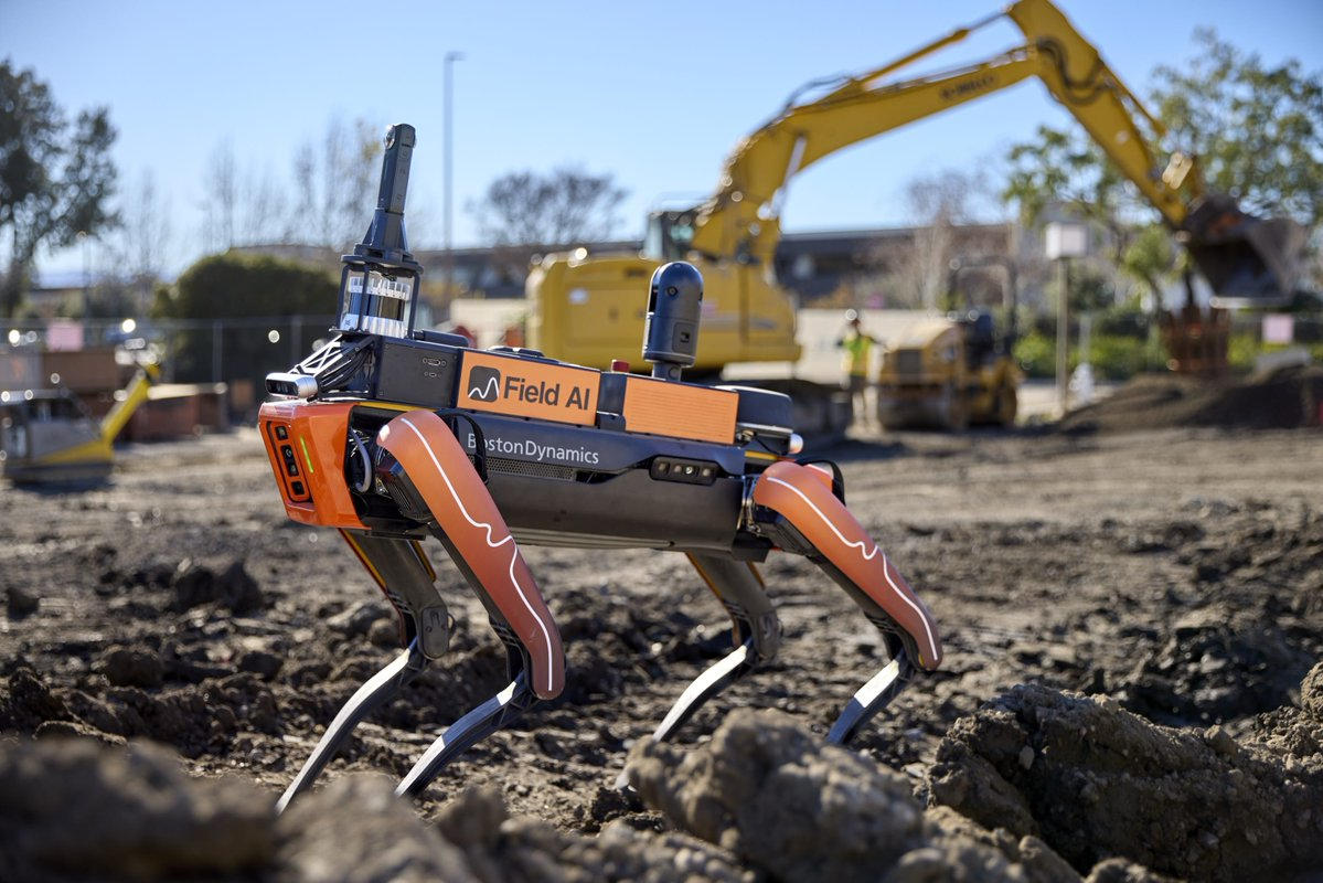 A four-legged robot on a construction site, labeled as a Field AI machine.